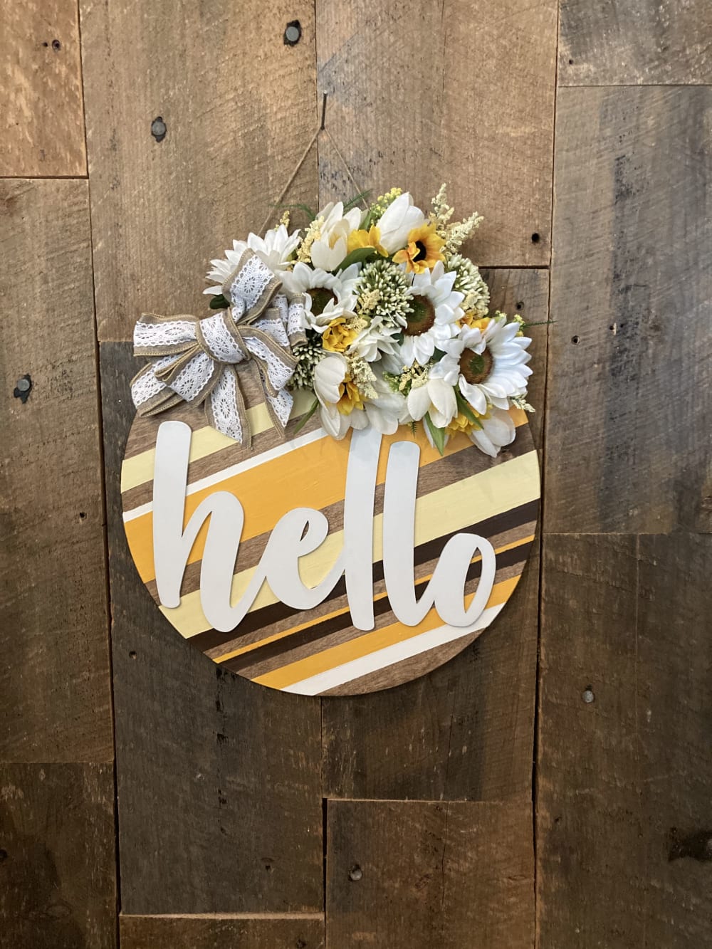 a striped door hangar that says hello