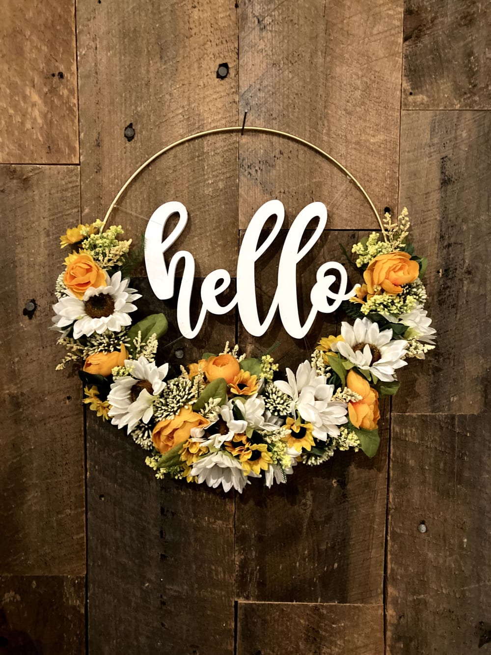 a gold hoop wreath that says hello